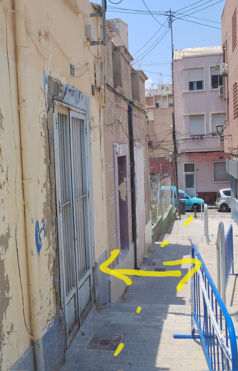 Un muro al borde del colapso y casas en ruinas