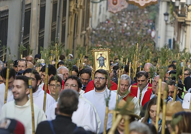 Peregrinos caminando hacia la Santa Faz en Alicante con cañas de romero